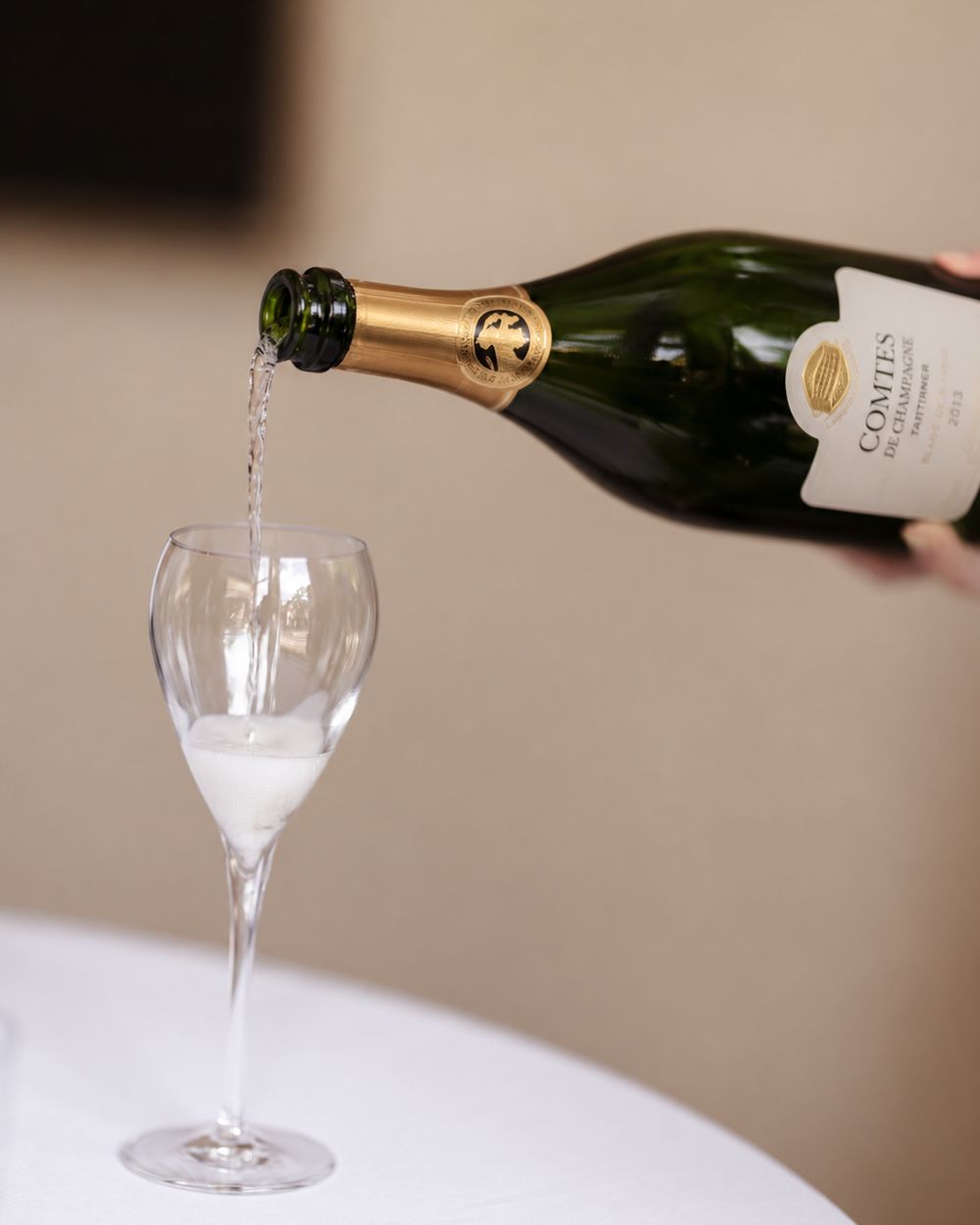 A bottle of Taittinger Comtes de Champagne being poured into a glass at the CreativeGrounds x Taittinger champagne tasting