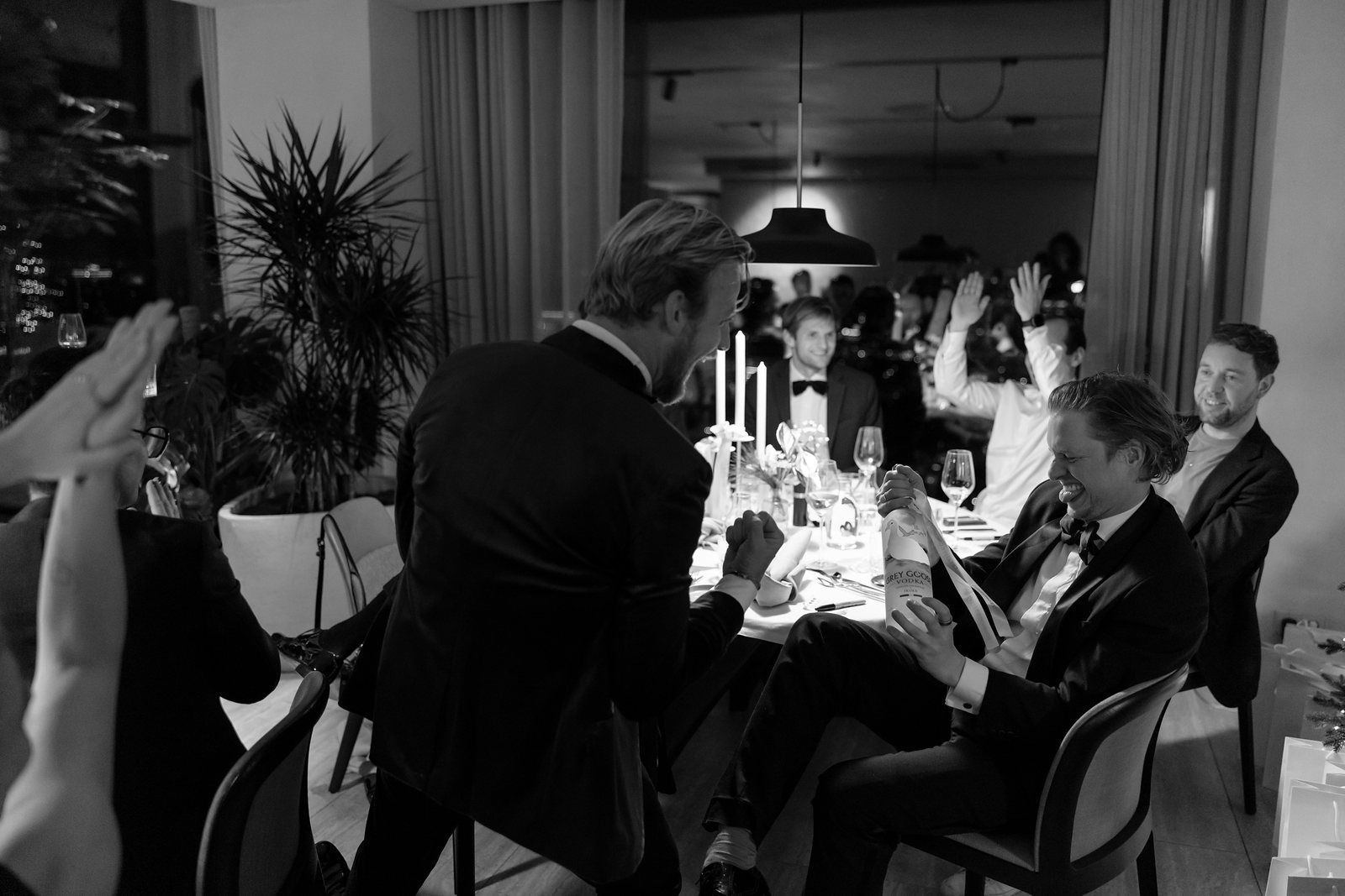 Black-tie members' dinner at CreativeGrounds, Amsterdam Oud-Zuid, with two members laughing by candlelight at a long table
