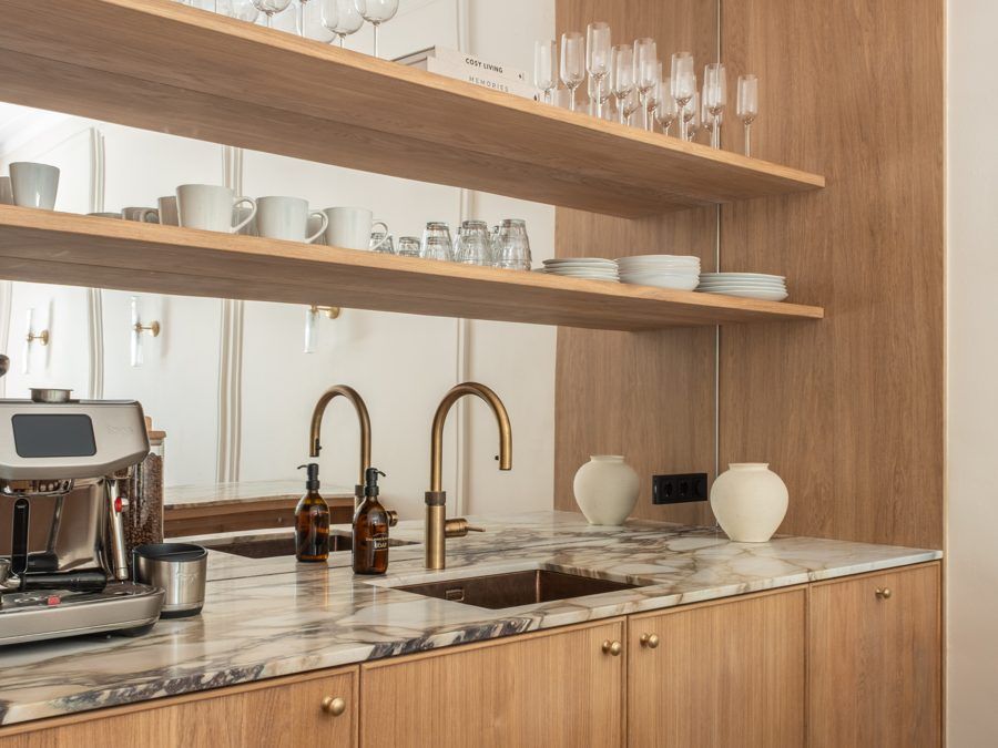 Pantry at CreativeGrounds with oak cabinets, open shelves with glassware and a coffee machine