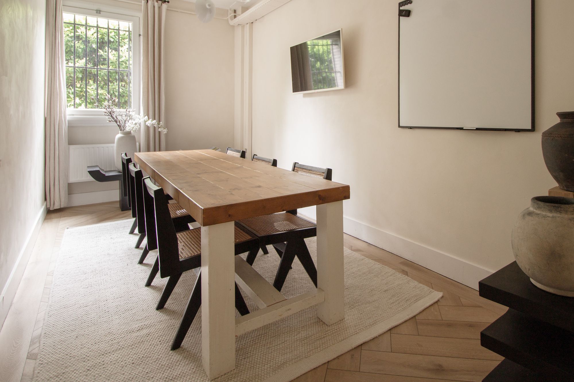 Ambition meeting room at CreativeGrounds coworking, Amsterdam Oud-Zuid, with a wooden table, black chairs and a whiteboard