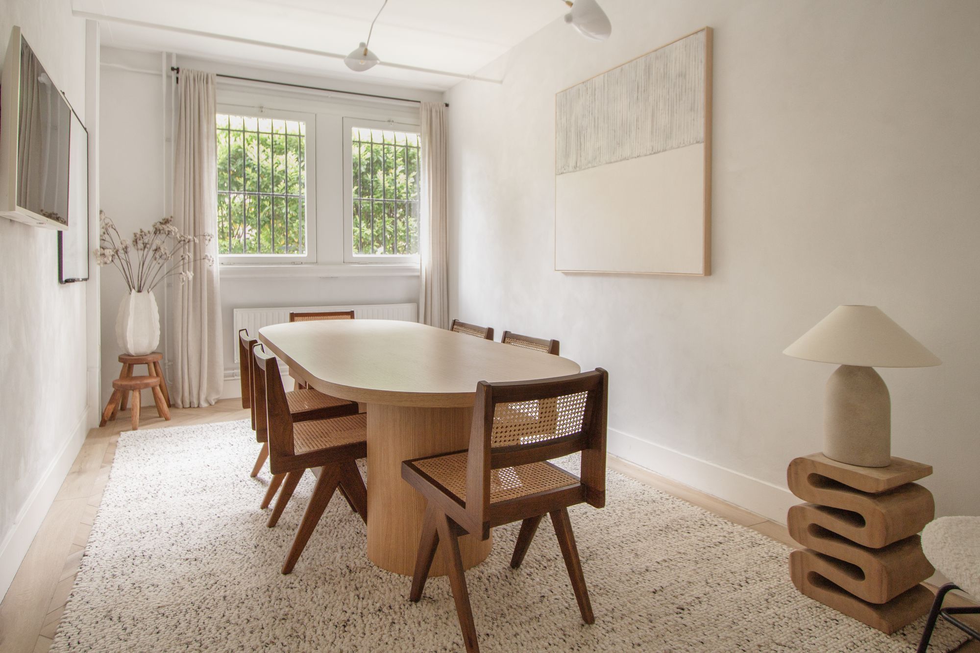 Journey meeting room at CreativeGrounds coworking, Amsterdam Oud-Zuid, with an oval oak table, cane chairs and a sculptural lamp