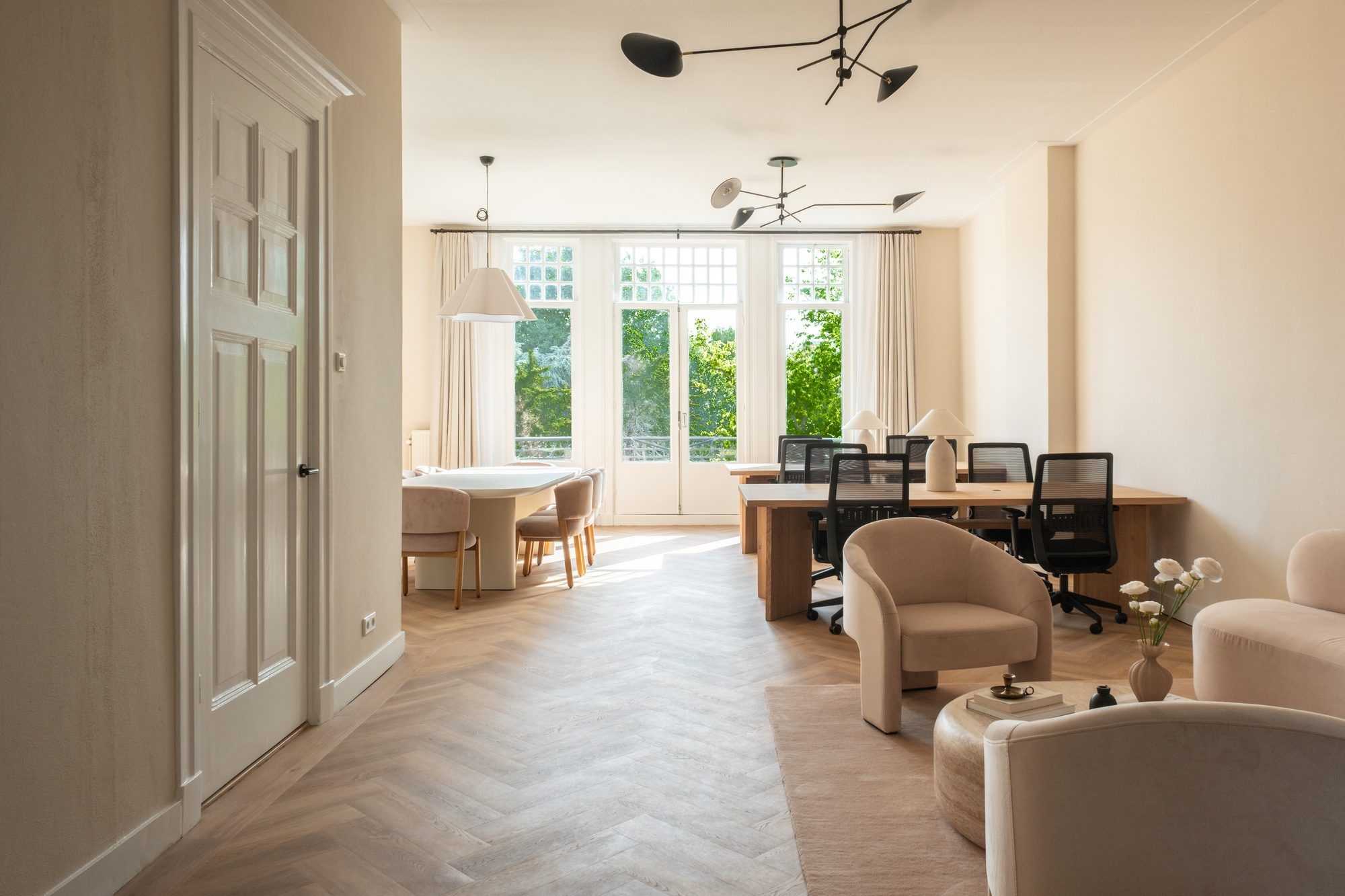 Bright private office with armchairs and oak desks by the garden doors in a CreativeGrounds villa, Amsterdam Oud-Zuid