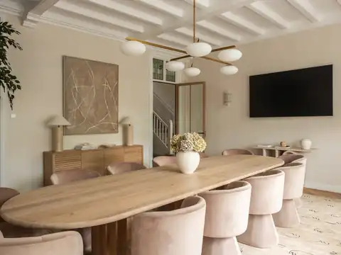 Meeting room with a long oak table, pink chairs and a globe chandelier