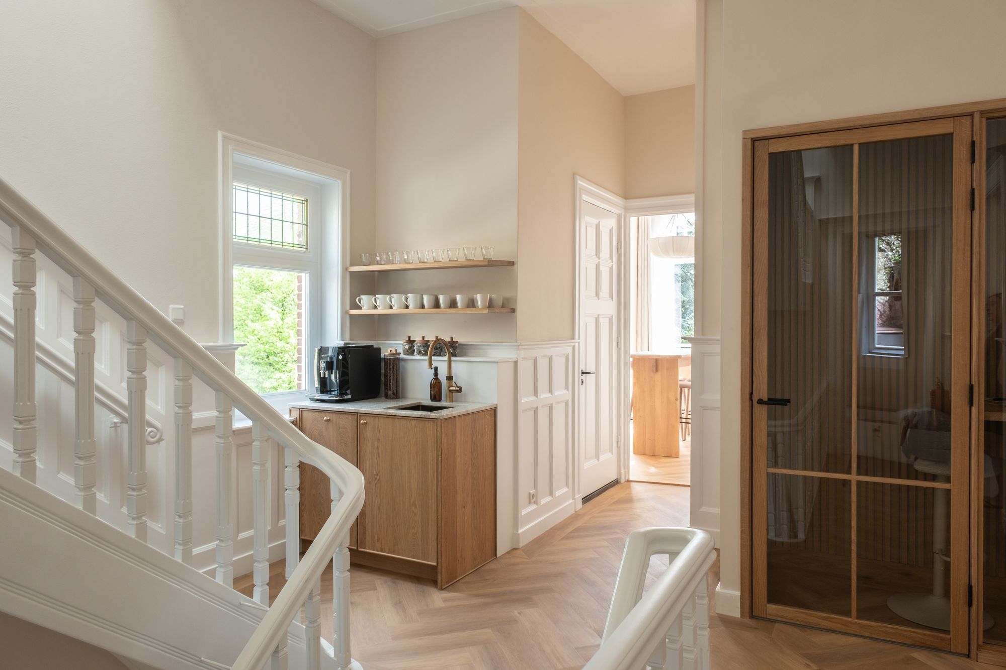 Staircase landing with a pantry and coffee machine next to the private office suite in a CreativeGrounds villa, Amsterdam Oud-Zuid